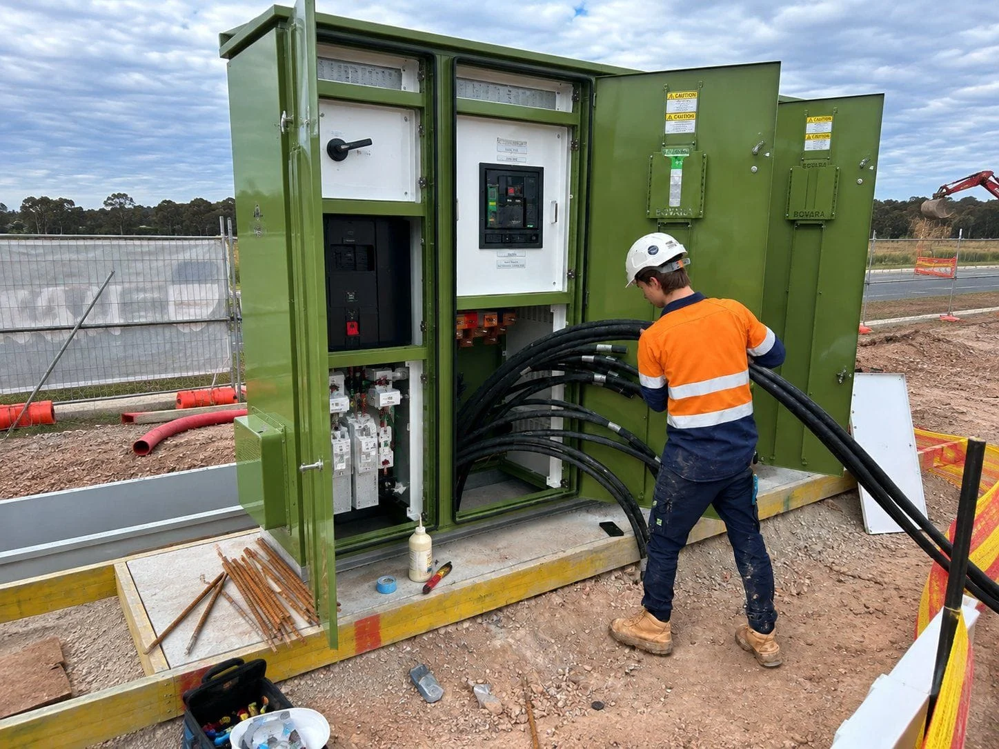 LCJ Group electricians cabling a green electrical kiosk on site